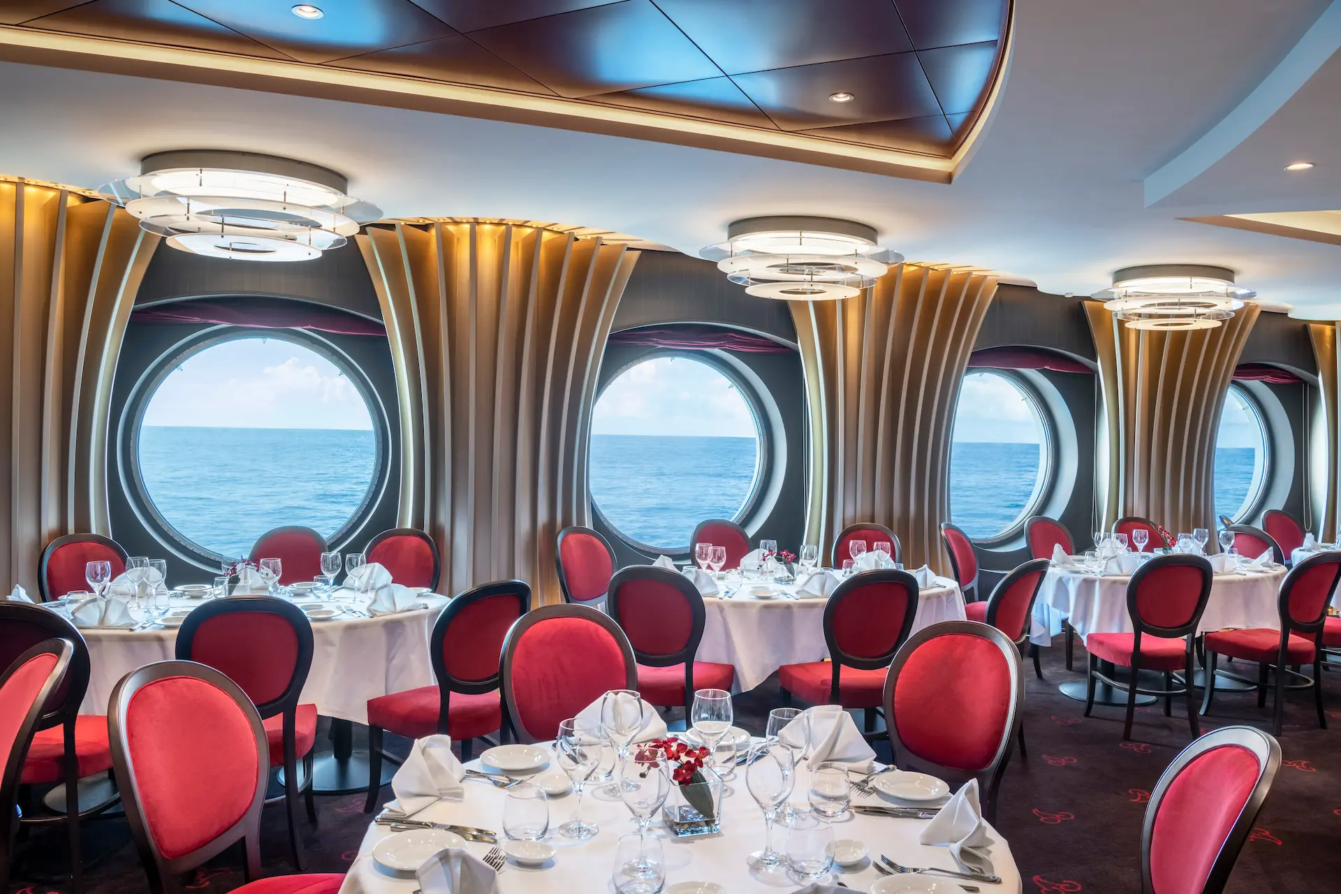Elegant restaurantinterieur met ronde patrijspoorten aan boord van MSC Bellissima.