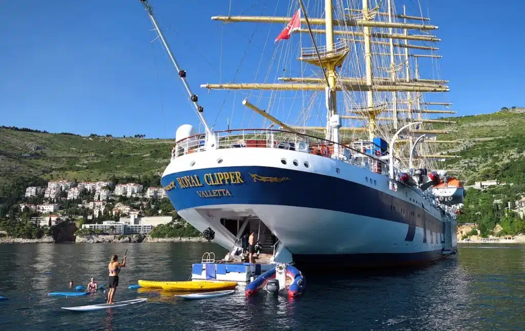 Gasten genieten van watersporten zoals suppen en kanoën vanaf het uitgeklapte marina-platform aan de achterzijde van het zeilschip Royal Clipper.