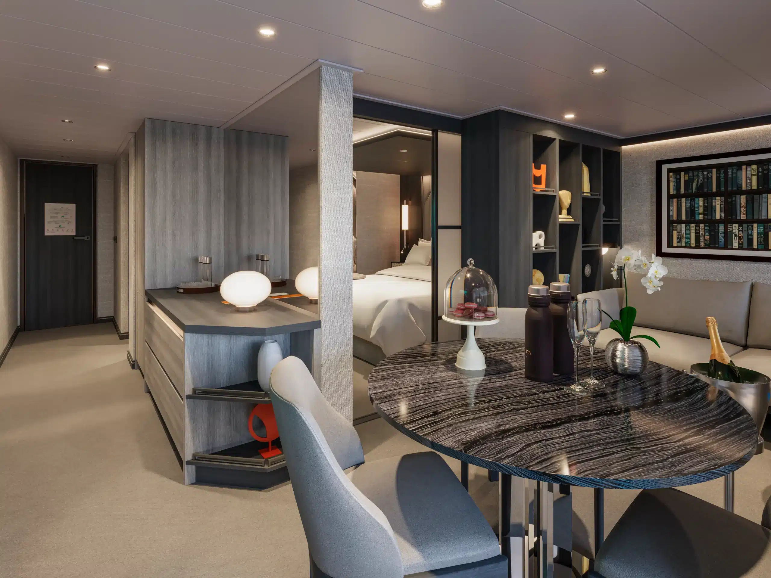 Modern interieur van het Premier Penthouse op de EXPLORA V, met een ronde eettafel, een comfortabele zithoek en een glazen schuifdeur naar het privébalkon.