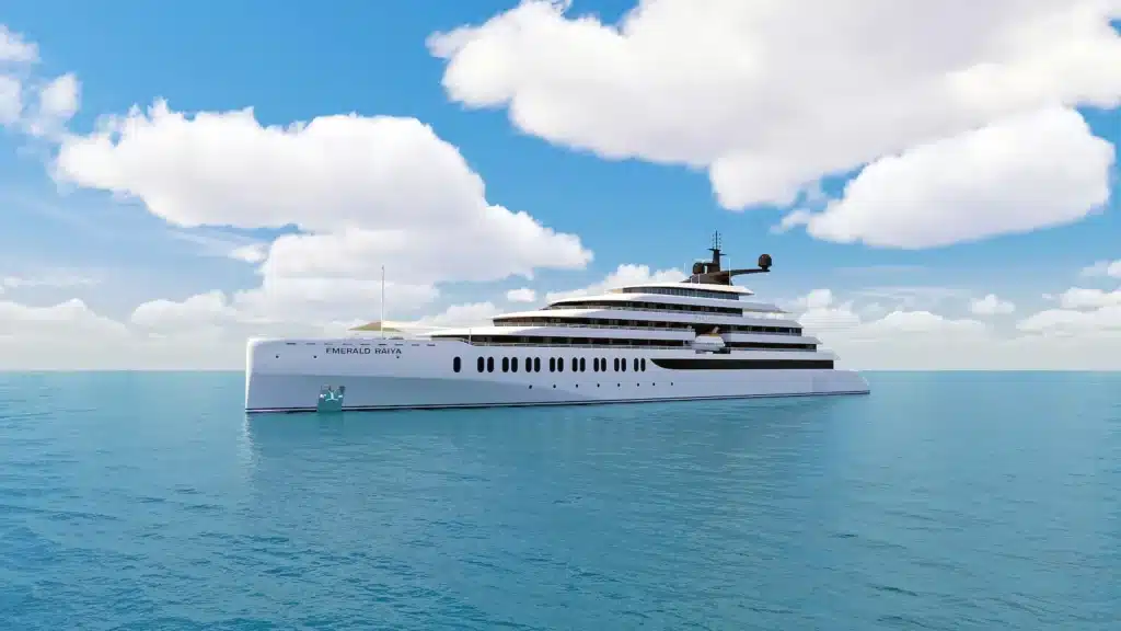 Een vooraanzicht van het luxe cruisejacht Emerald Raiya varend op een helderblauwe zee onder een lichtbewolkte hemel.