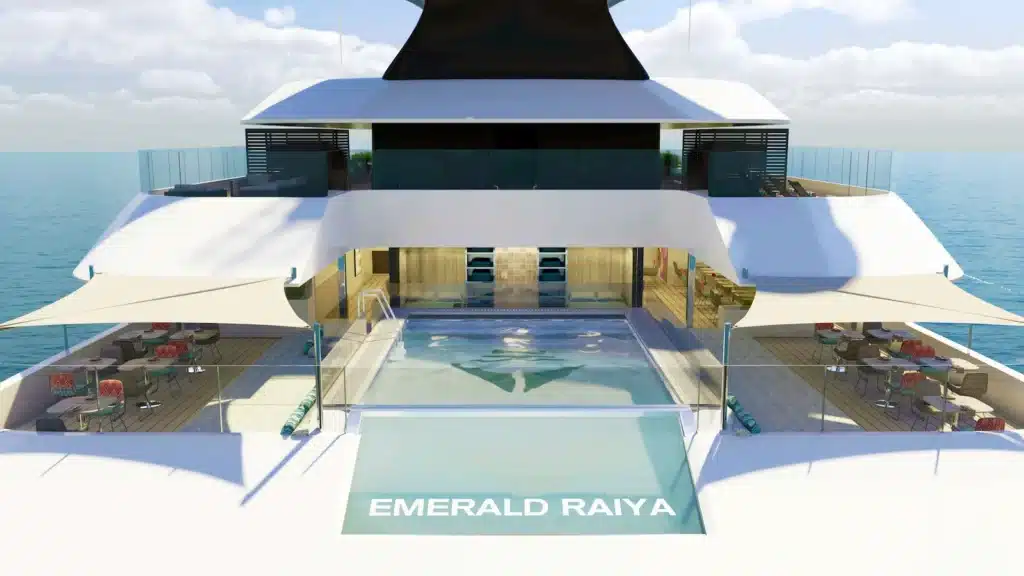 Een exterieur impressie van het luxe cruisejacht Emerald Raiya, varend op een rustige blauwe zee onder een licht bewolkte lucht.