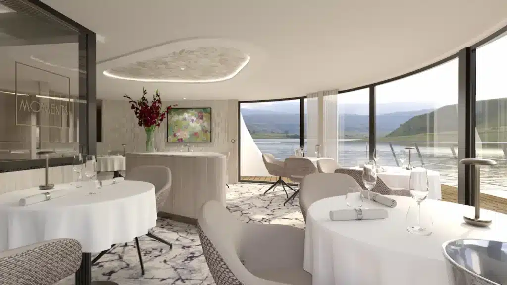 Modern interieur van het Moments Restaurant aan boord van de VIVA UNIQUE, met elegant gedekte tafels, panoramische ramen en uitzicht op de rivier.